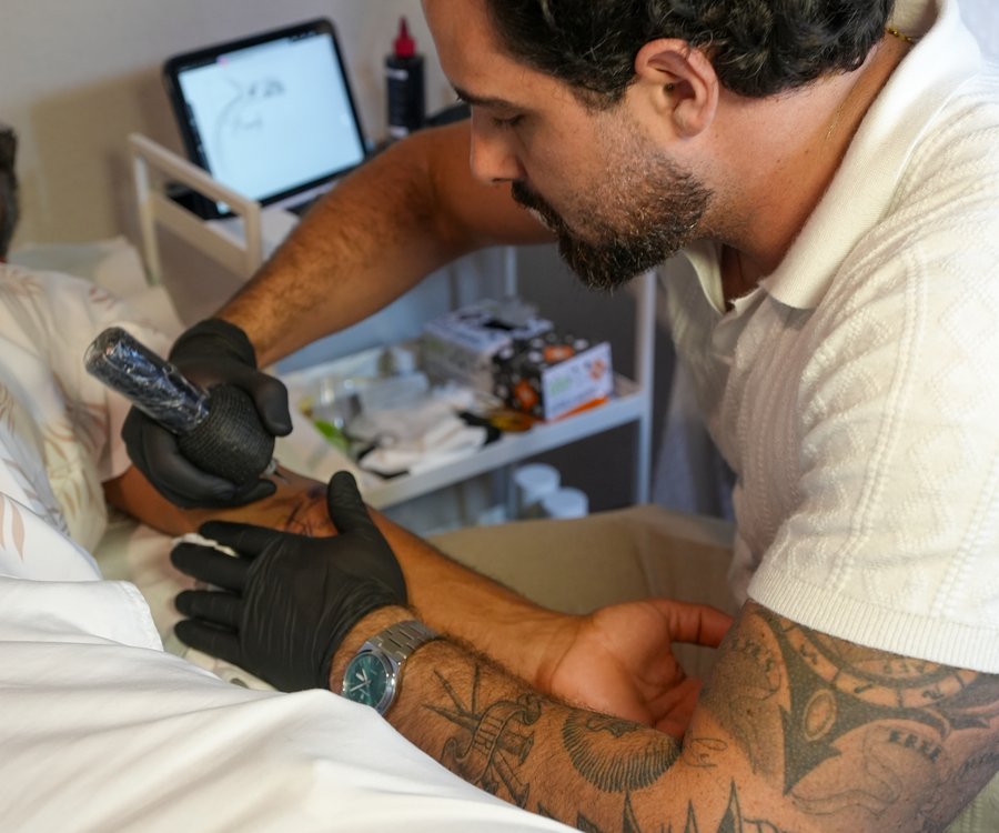 Tatuador trabajando con guantes y material estéril